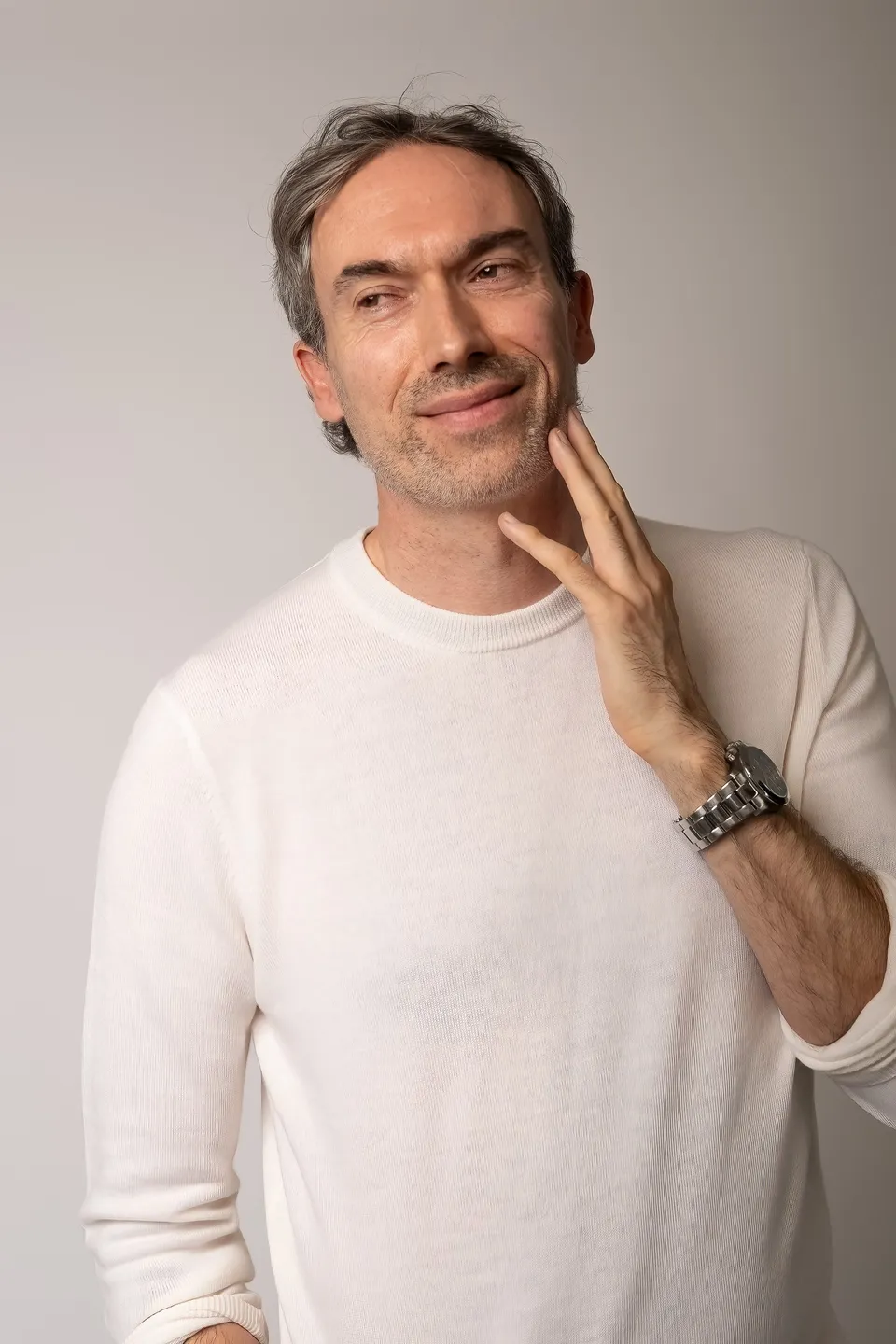 Kieron C, white jumper, hand to face